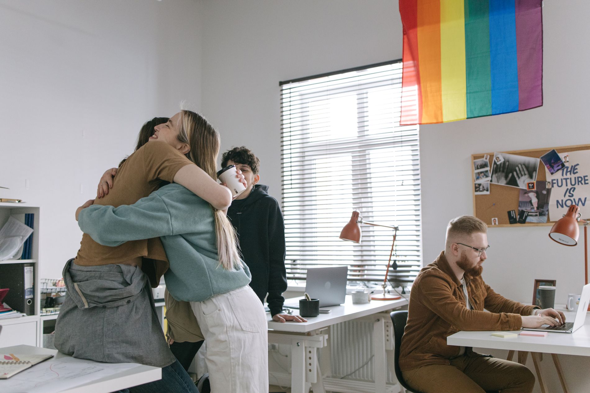The LGBTQ+ team behind RainbowXRP beneath a Pride flag